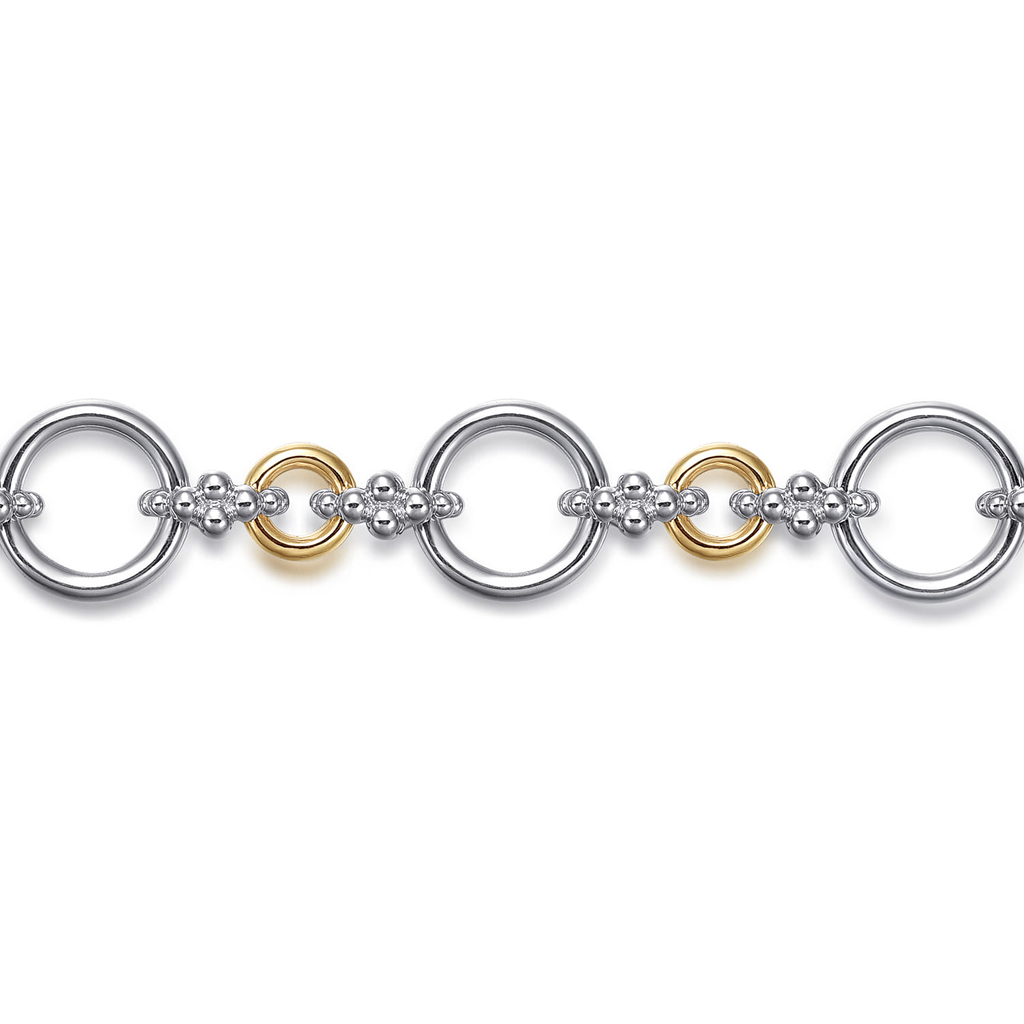 silver and gold tone round link bracelet on white background