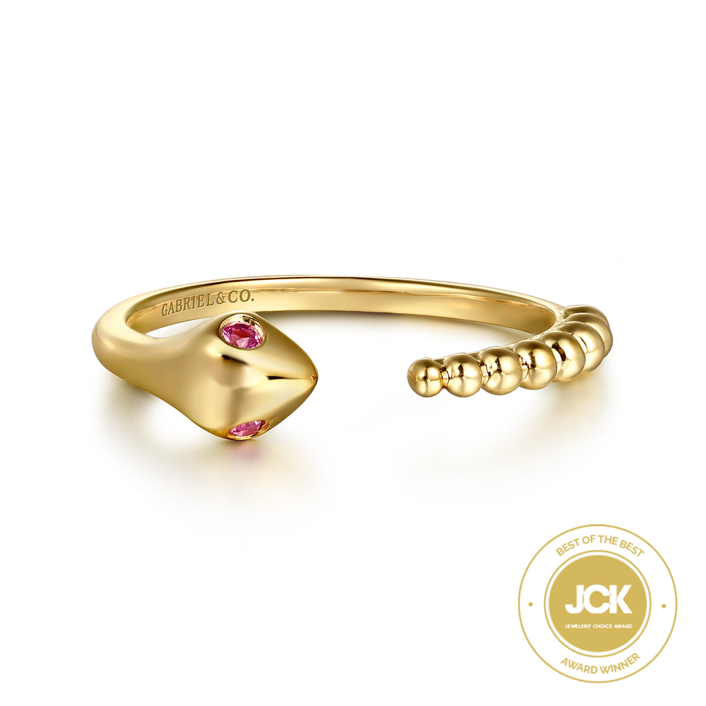 Gold ring with pink gemstones on a white background, featuring the JCK logo.