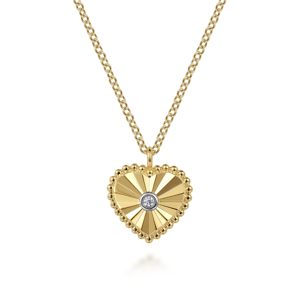 Gold heart-shaped necklace with a diamond on a white background