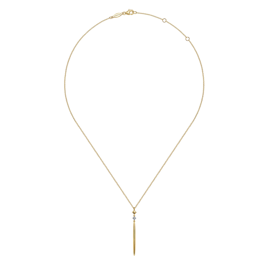 Gold necklace with a tassel pendant on a white background