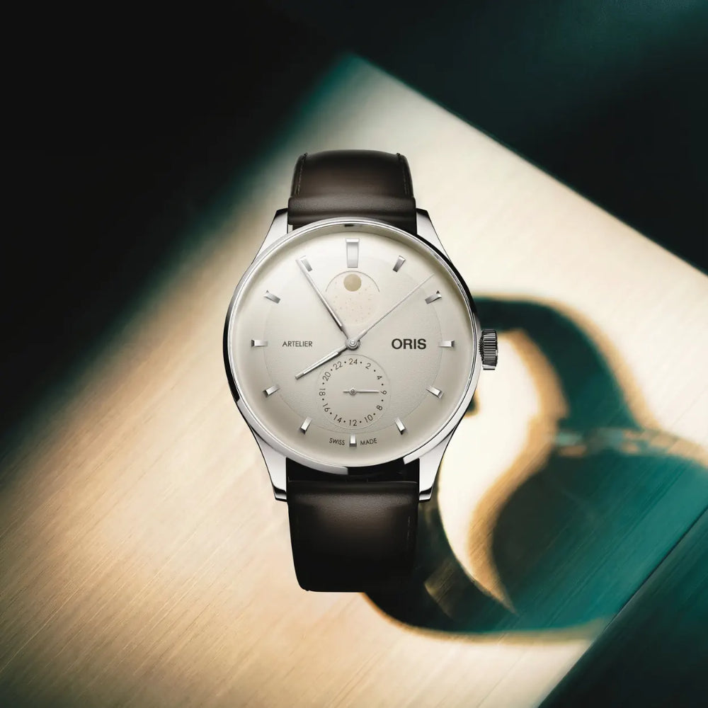 Oris watch with a ivory dial and black leather strap on a wooden surface