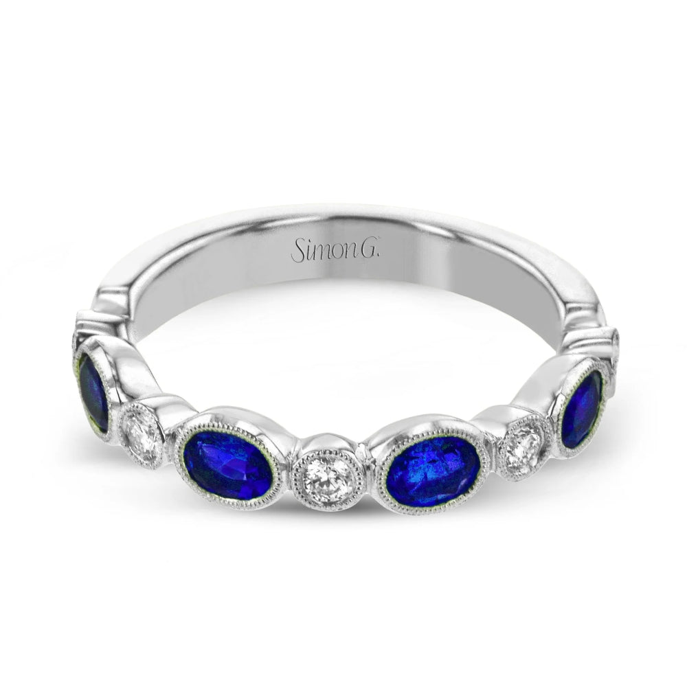 Silver ring with blue gemstones and diamonds on a white background