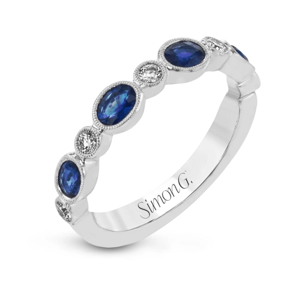 Silver ring with blue gemstones and 'Simon G.' engraving on a white background