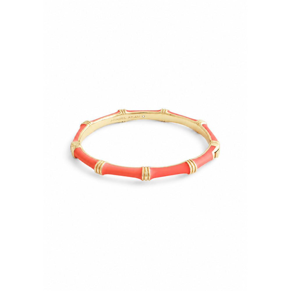 Bracelet with red coral tube and gold accents on a white background