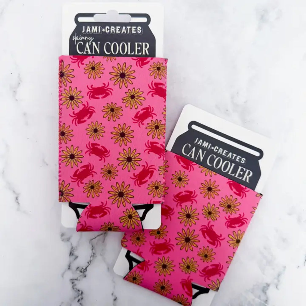 Pink can cooler with crab and flower pattern on a marble surface