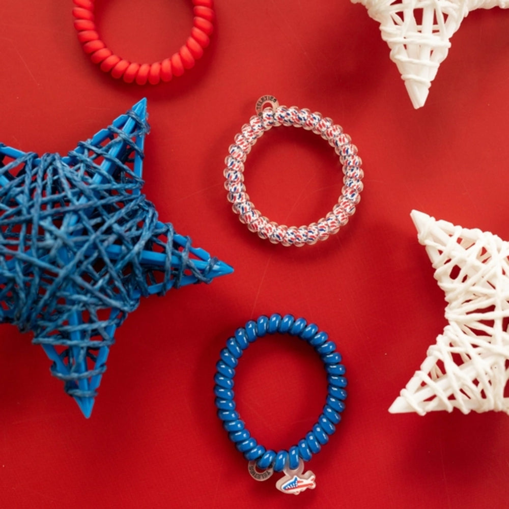 Colorful hair ties on a red background with decorative items.