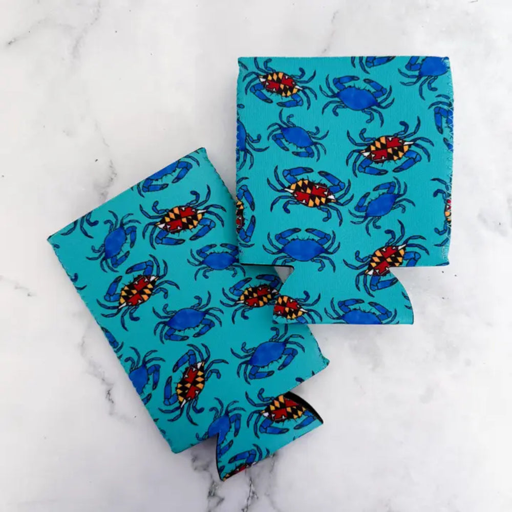 Two can coolers with blue crab patterns on a marble surface
