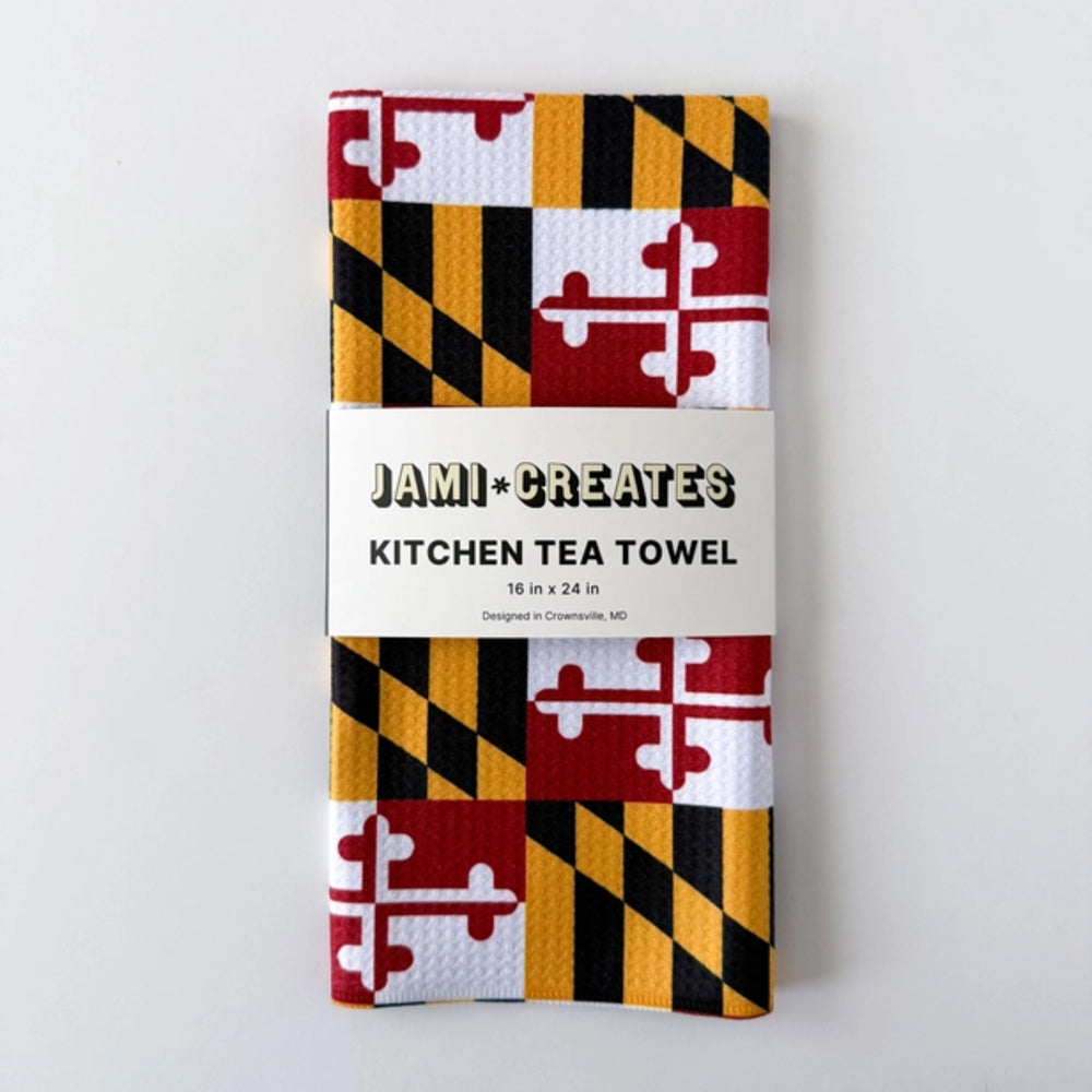 Kitchen tea towel with Maryland flag design and 'Jami Creates' branding on a white background