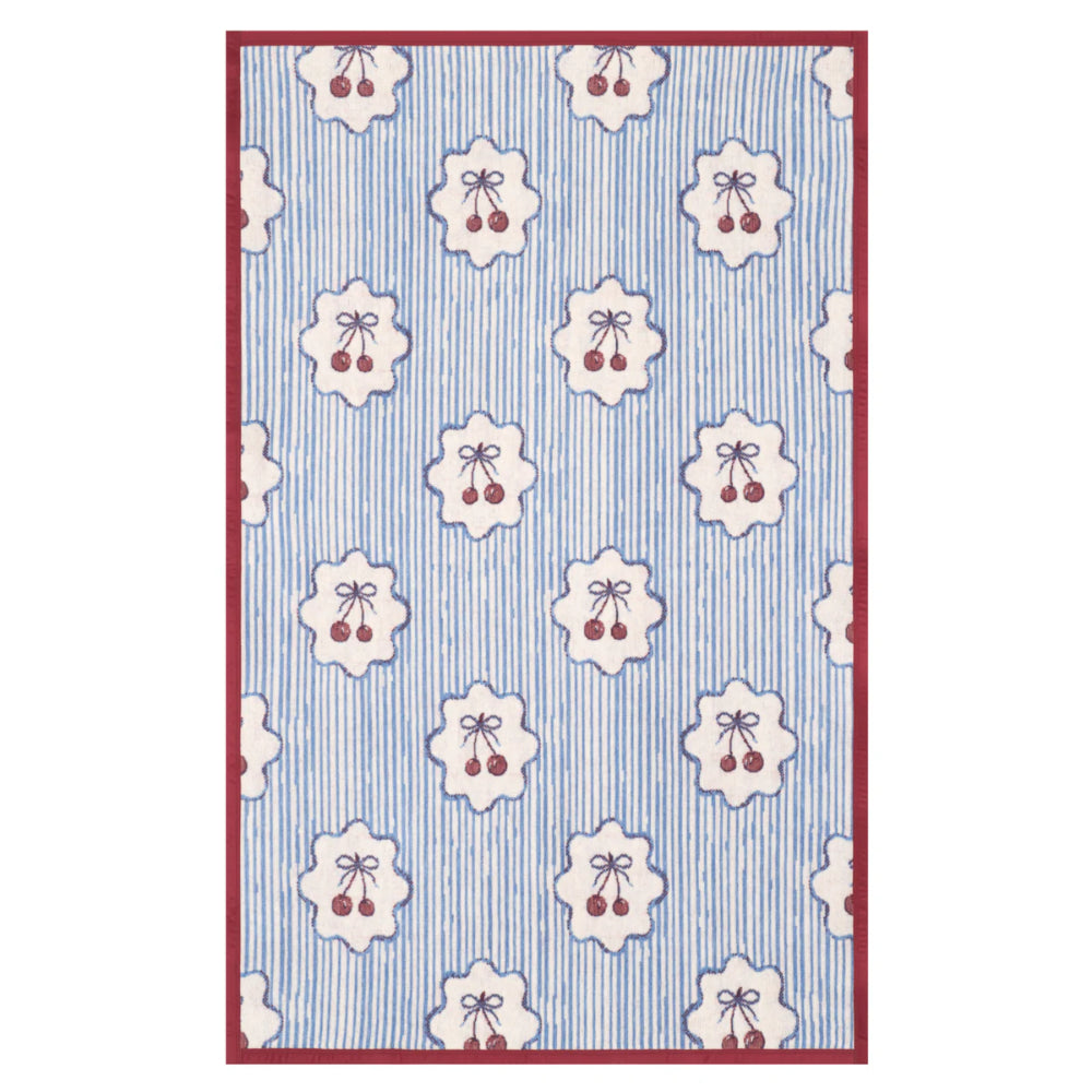 Patterned blanket with floral and berry design on a blue and white striped background