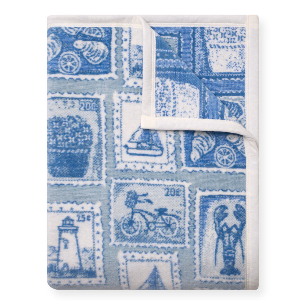 Folded blanket with blue and white stamp pattern on a white background