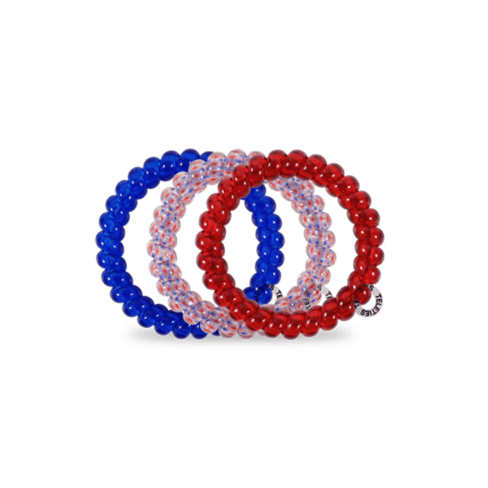 Set of three beaded hair ties in blue, red, and white on a white background