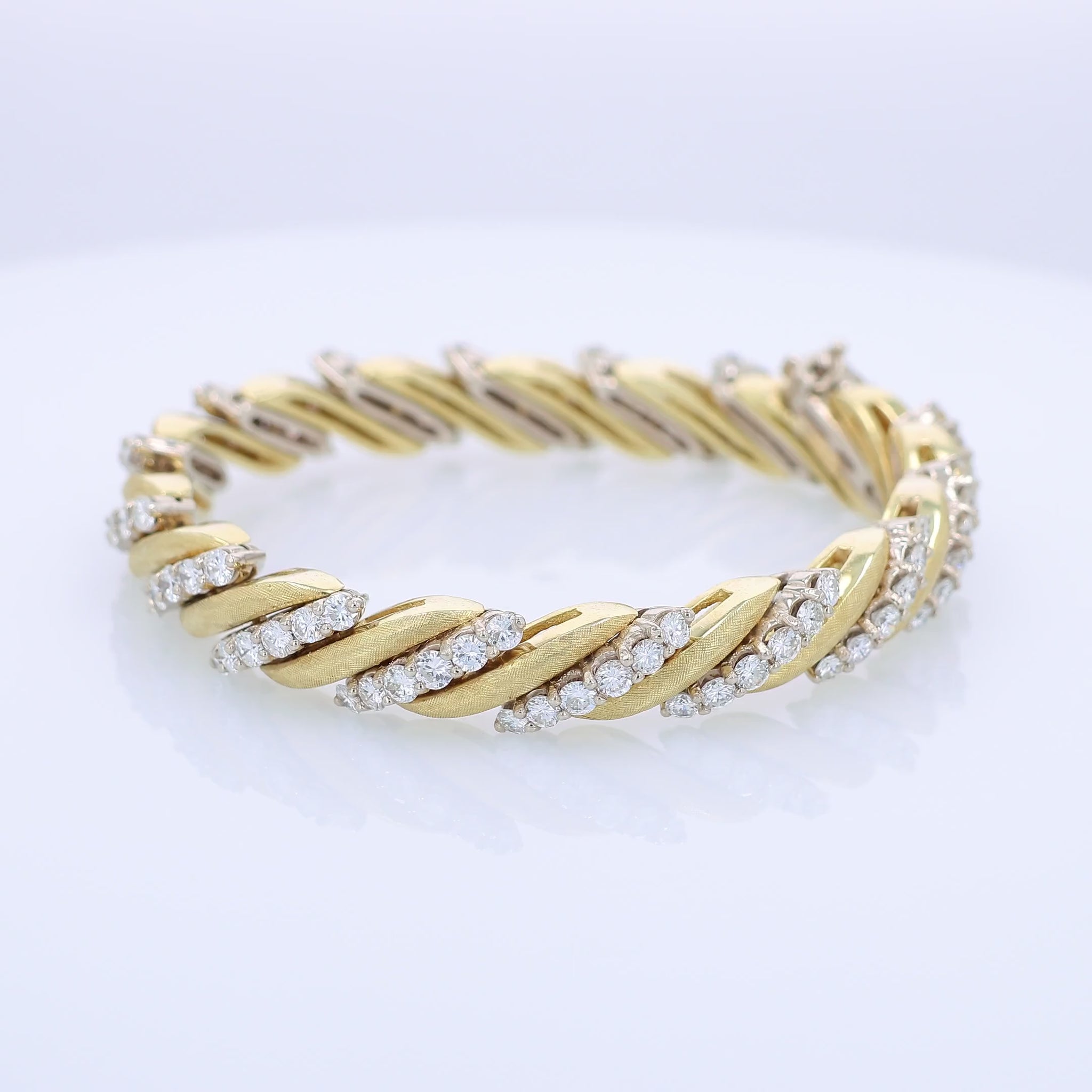 360 degree video of a two-tone gold bracelet with diamond accents on a white background