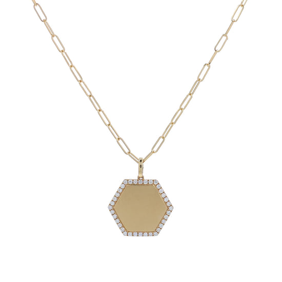 A gold hexagonal pendant necklace with a pavé diamond border and a paperclip chain, shown on a white background
