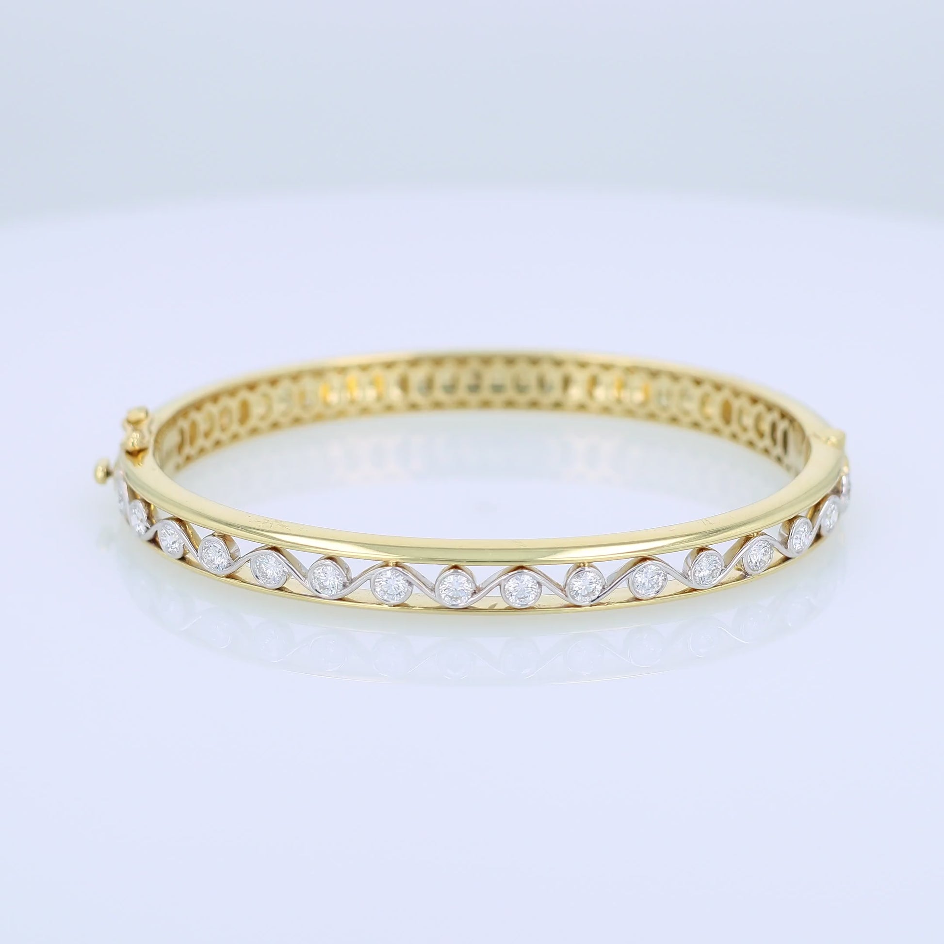 Gold bracelet with bezel-set diamond center accents on a white background