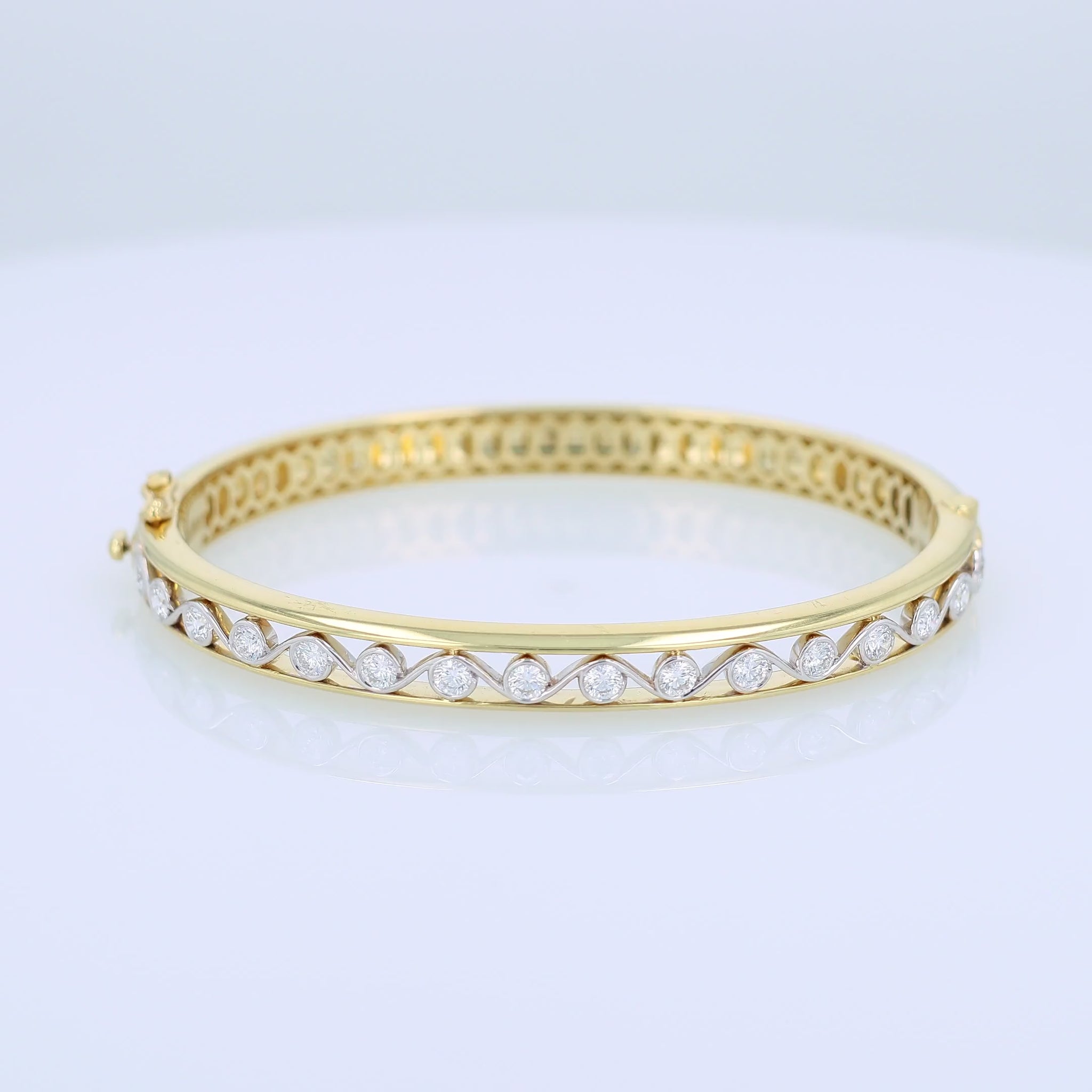 Gold bracelet with bezel-set diamond center accents on a white background