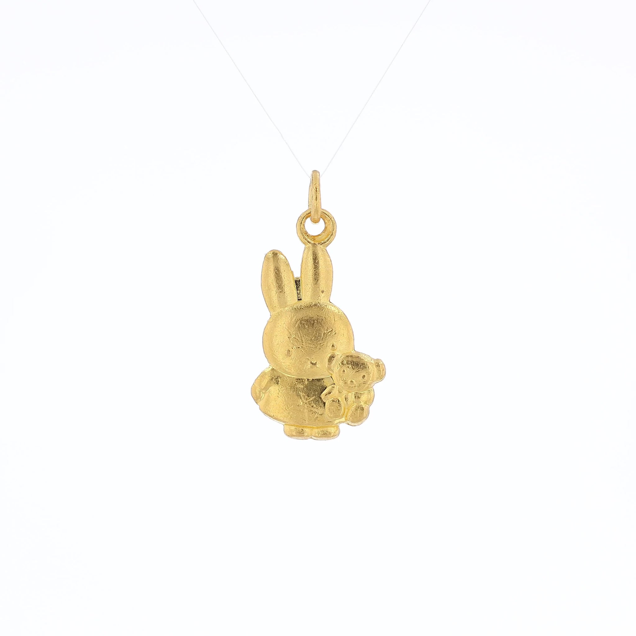 Yellow gold pendant depicting Miffy the Rabbit holding a stuffed animal bear on a white background