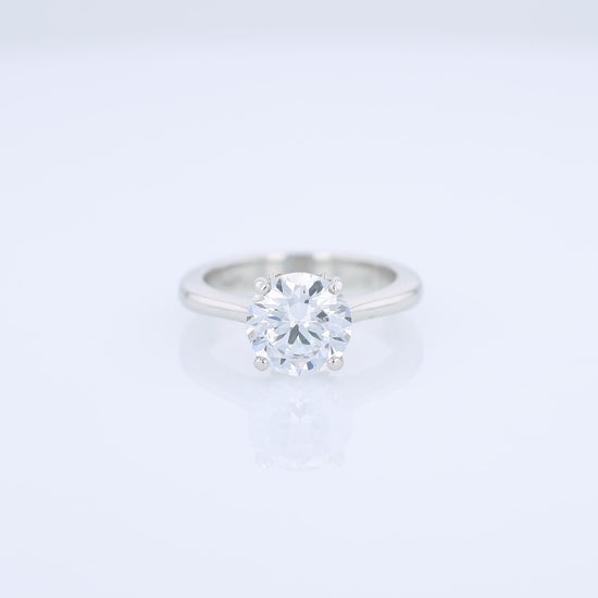 Platinum diamond solitaire engagement ring with a round cubic zirconia center on a white background