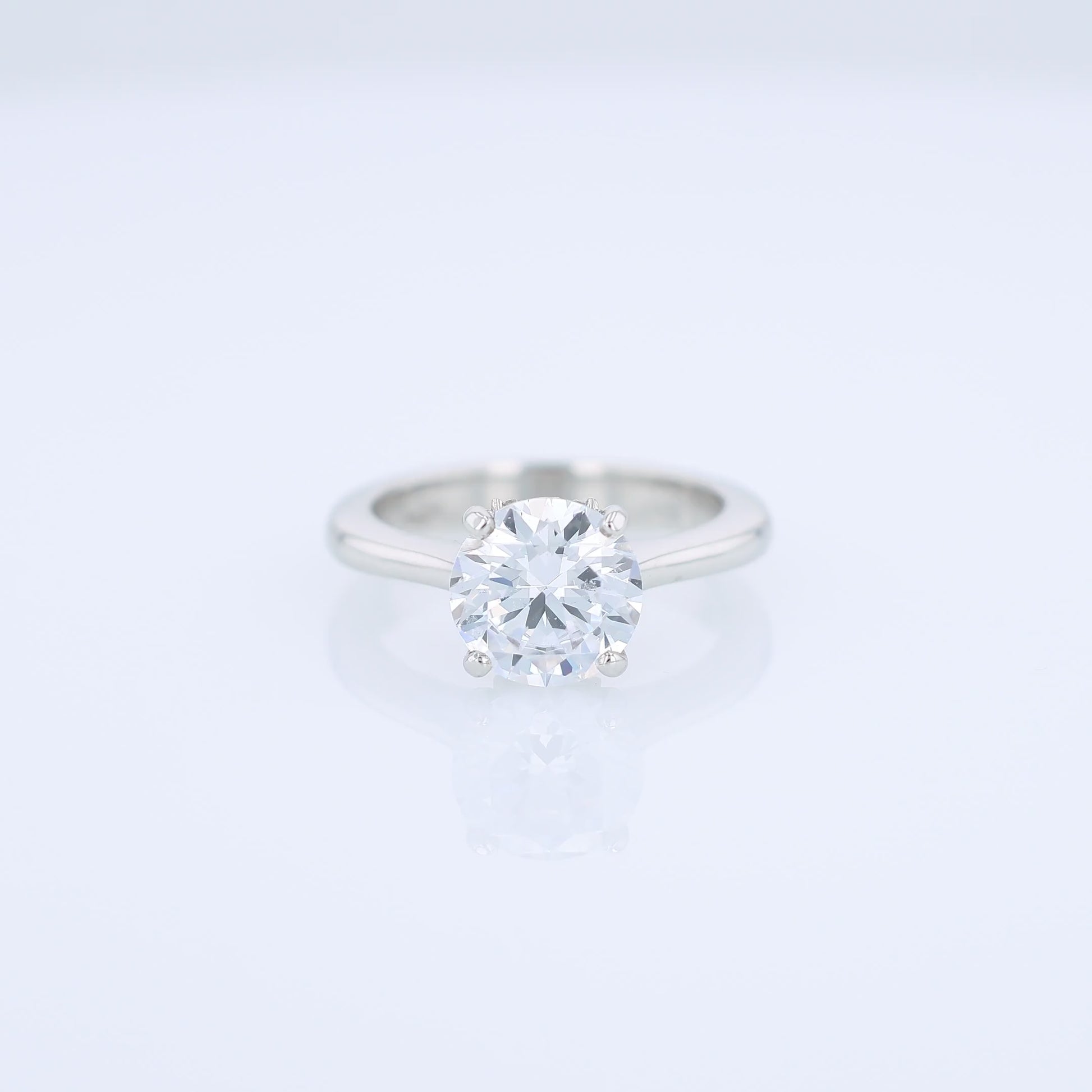 Platinum diamond solitaire engagement ring with a round cubic zirconia center on a white background