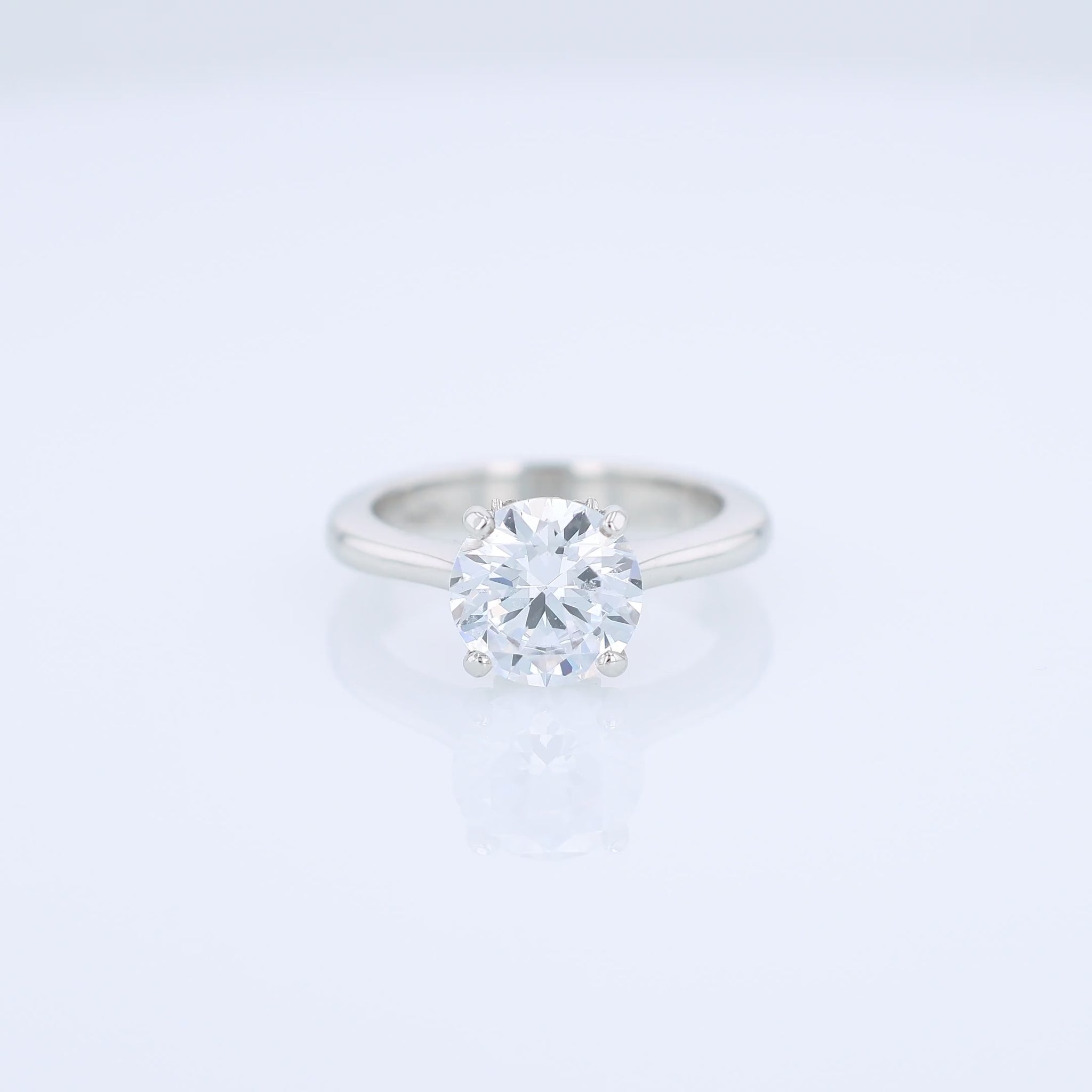 Platinum diamond solitaire engagement ring with a round cubic zirconia center on a white background