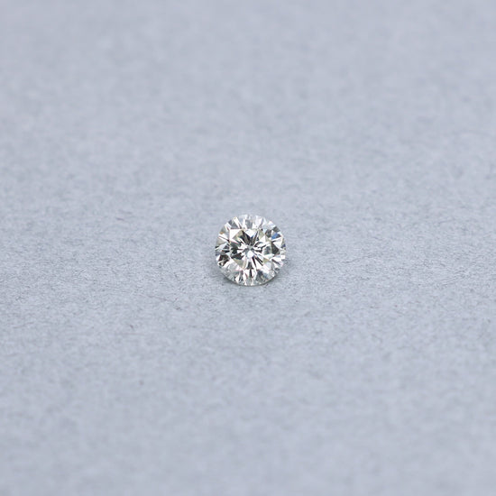 Round .95 carat diamond graded LVS1 on a grey background