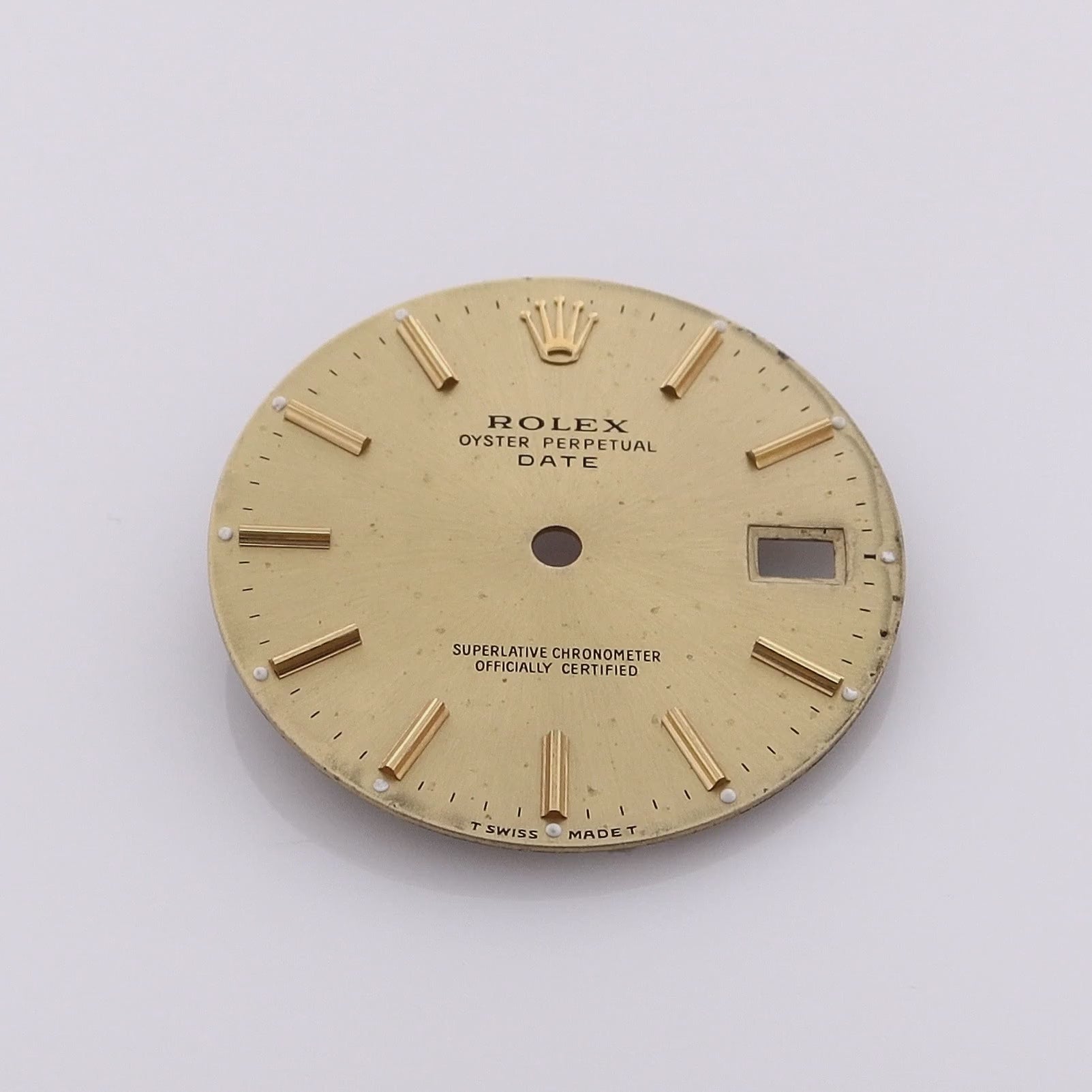 360 degree video of a champagne Rolex watch dial with stick indexes and a date display window.