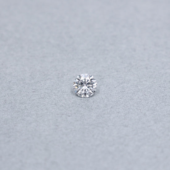 Round .90 carat triple excellent GIA certified diamond graded EVVS1 on a grey background