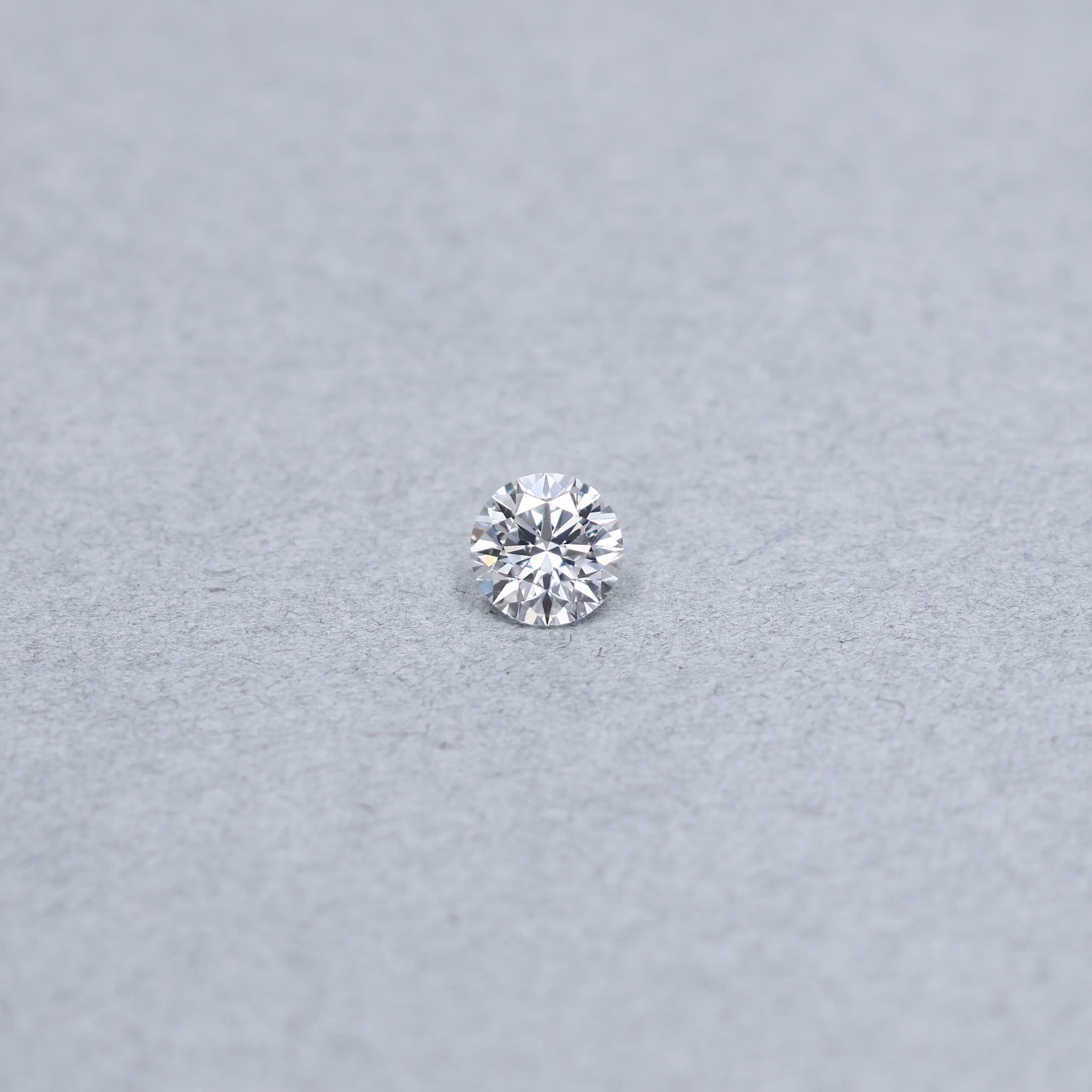 Round .90 carat triple excellent GIA certified diamond graded EVVS1 on a grey background