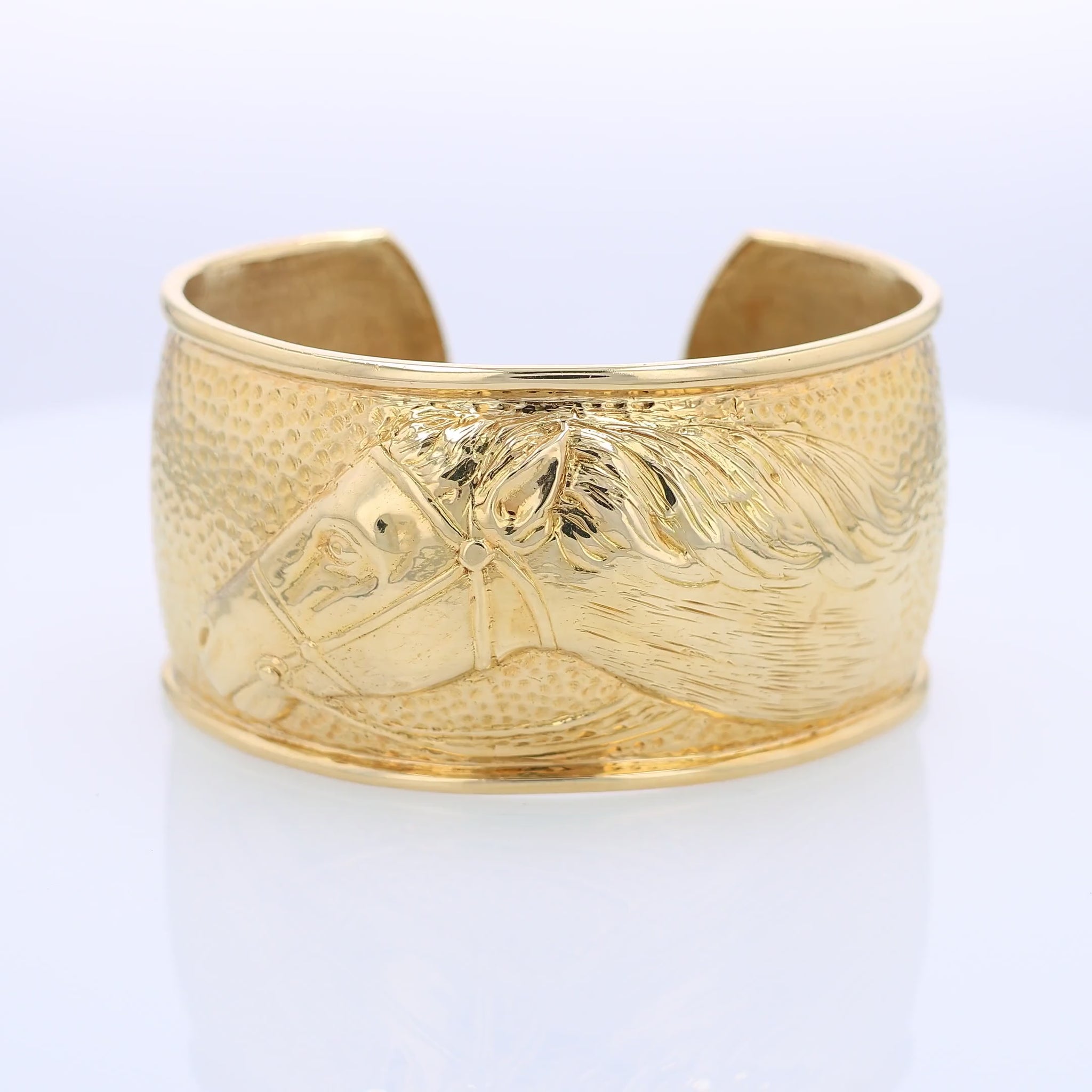 360 degree video of a gold cuff bracelet with horse head design on a white background