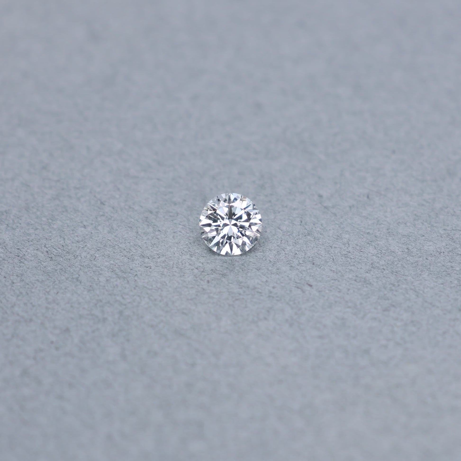 Round .79 carat diamond graded FSI1 on a grey background