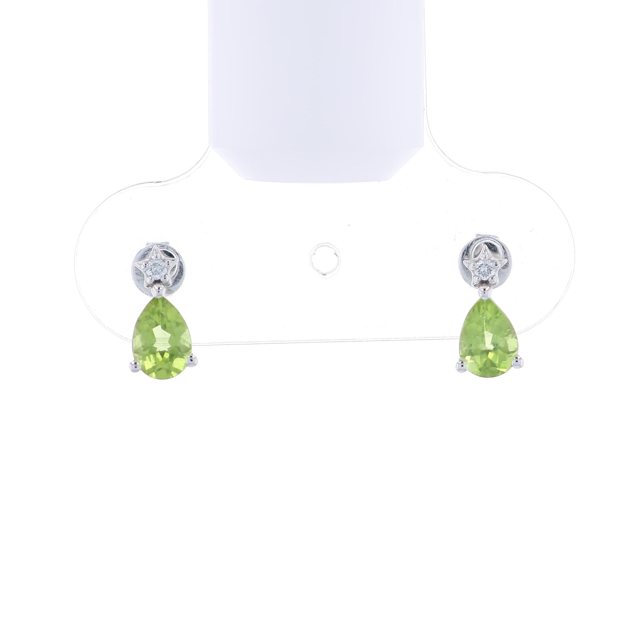 Pair of white gold earrings with pear shape peridot and diamond accents on a white background