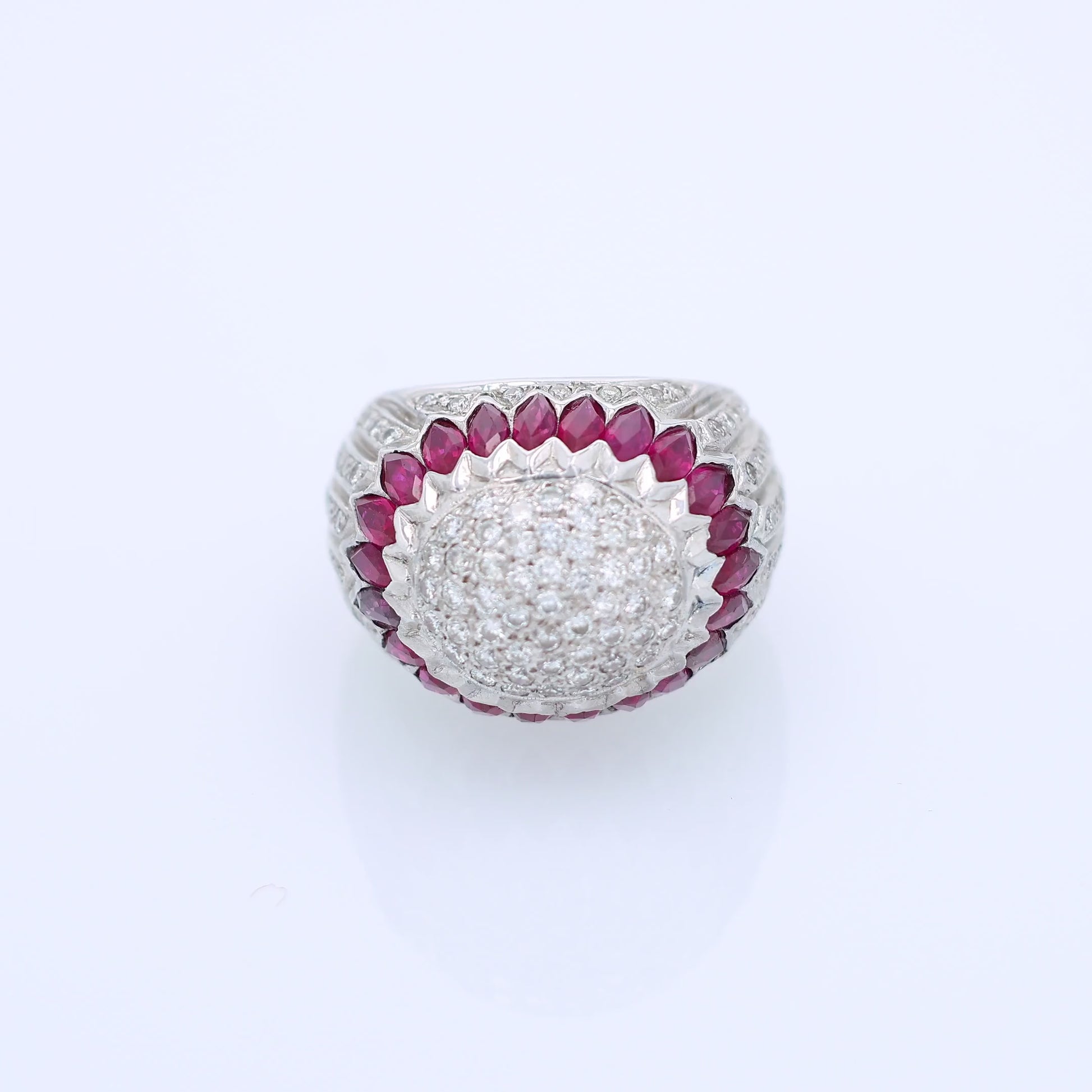 Elegant white gold ring with marquise rubies and diamond accents on a white background
