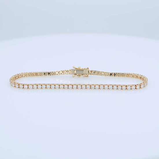 Yellow gold 3.40 carat diamond tennis bracelet on a white background