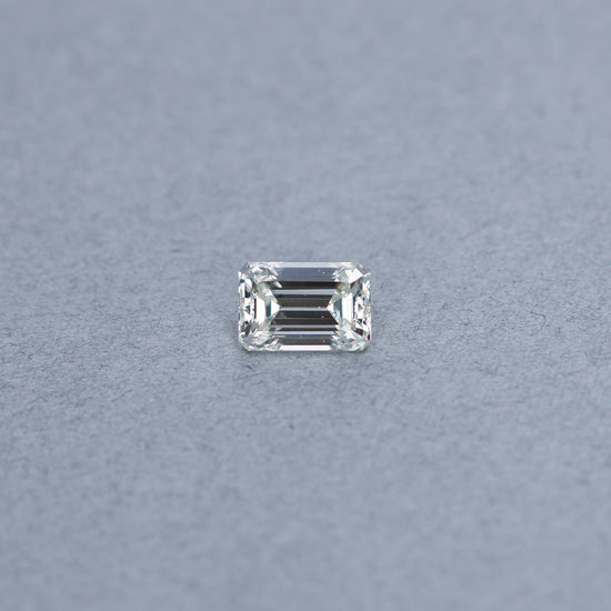 Emerald cut 2.45 carat GIA certified diamond graded JVS2 on a grey background