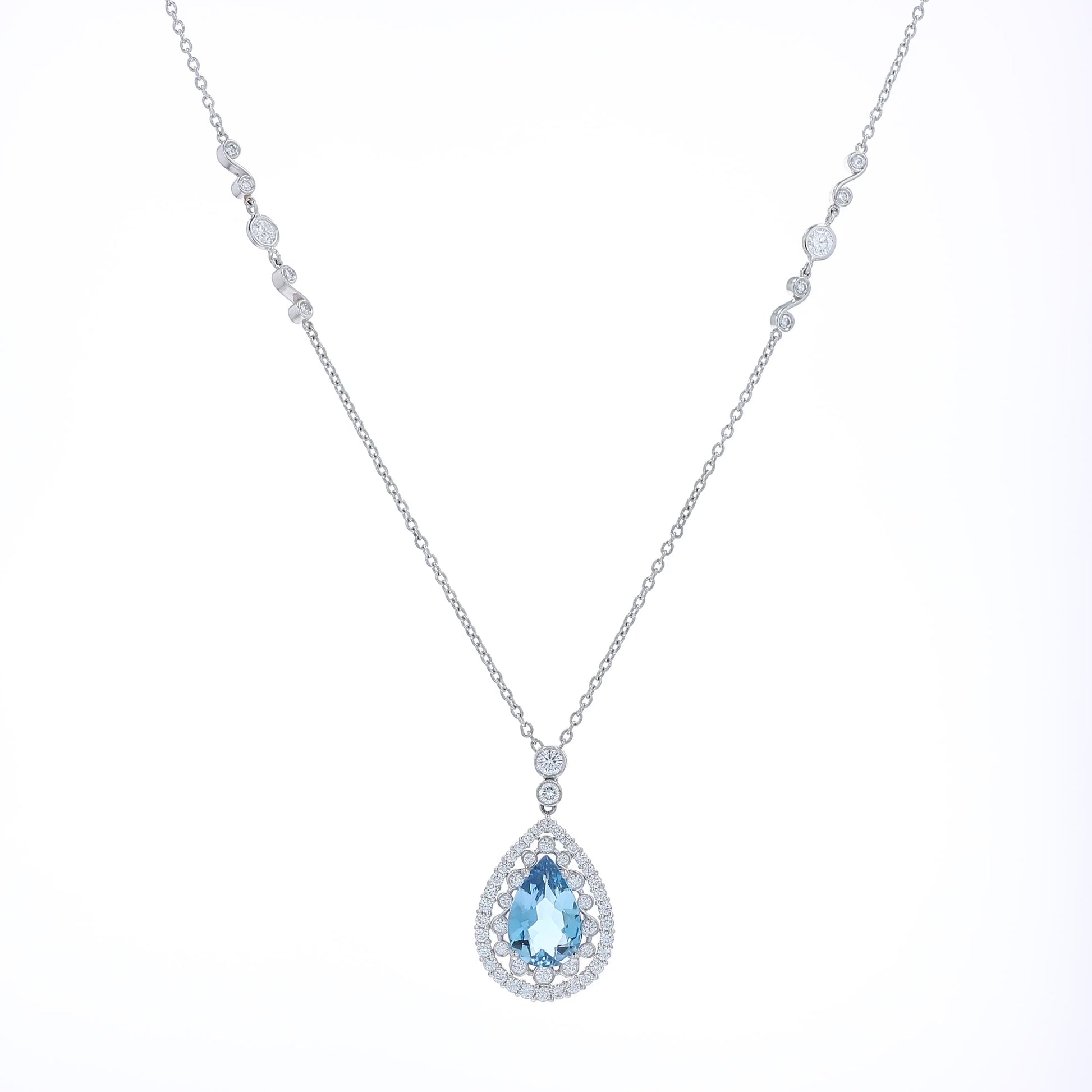 Platinum pear shaped aquamarine and diamond double halo pendant necklace with chain on a white background