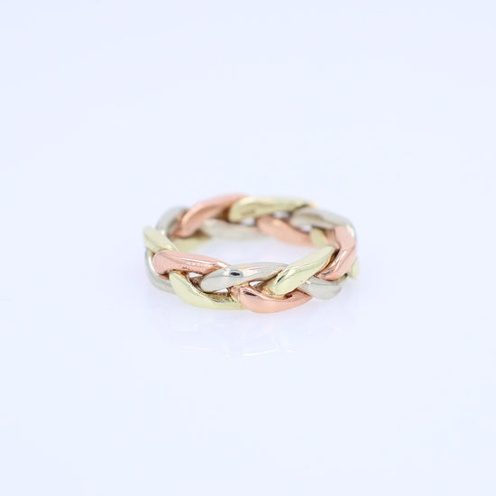Tri-tone gold braided link design ring on a white background