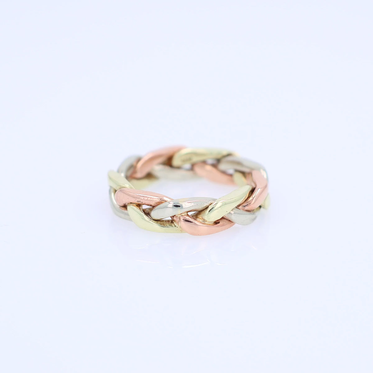 Tri-tone gold braided link design ring on a white background
