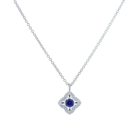 White gold diamond halo pendant necklace with a round blue sapphire center on a white background