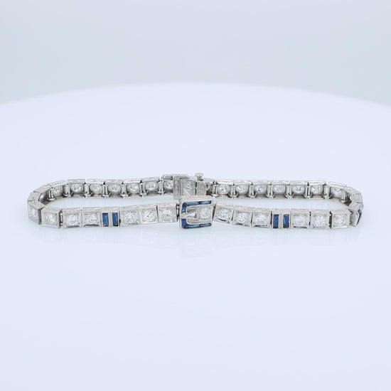 Platinum buckle design diamond and synthetic sapphire tennis bracelet on a white background