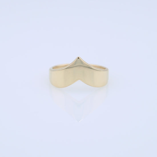 Polished gold chevron design ring on a white background