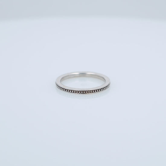White gold ring with a milgrain center row on a white background