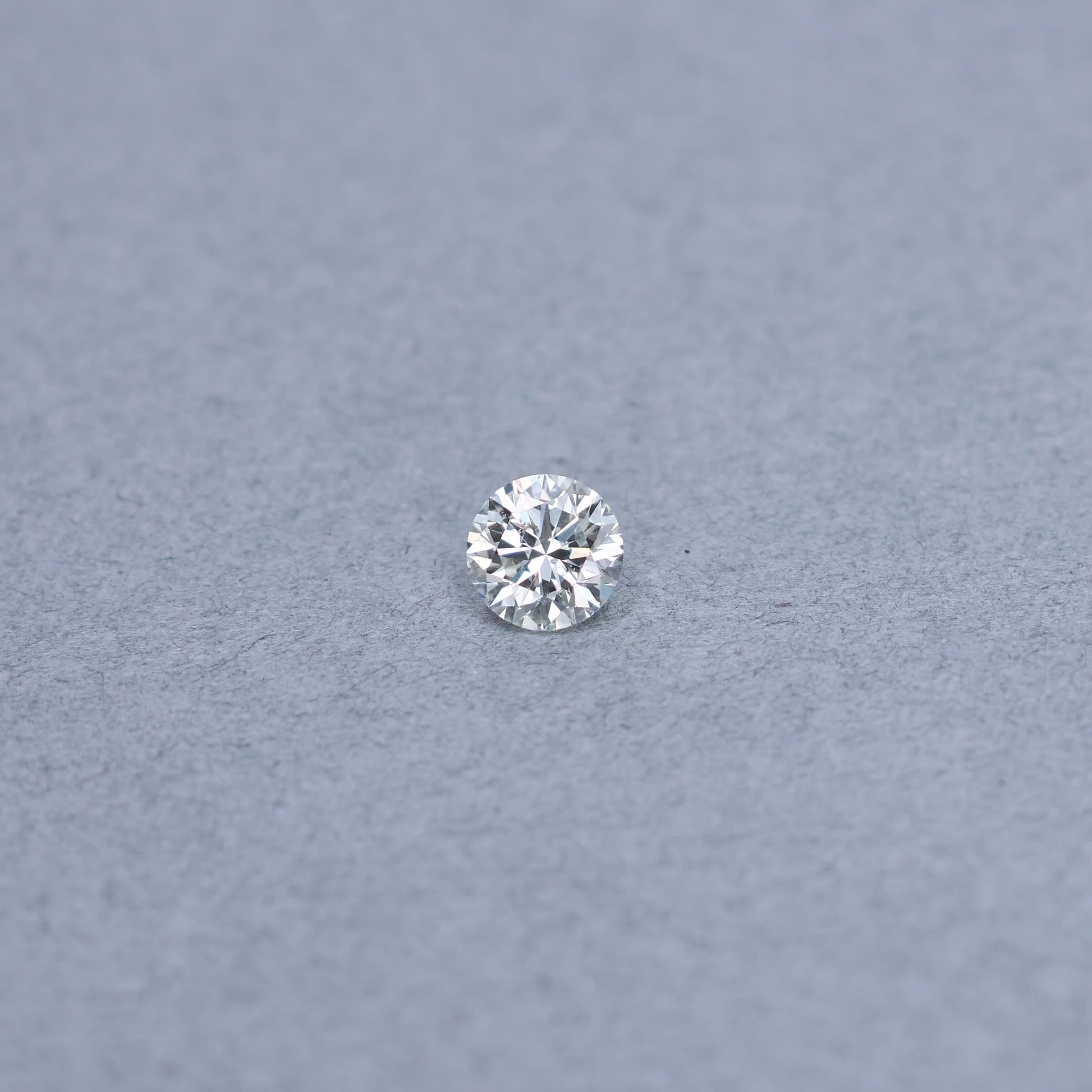 Round 1.01 carat diamond graded KI1 on a grey background