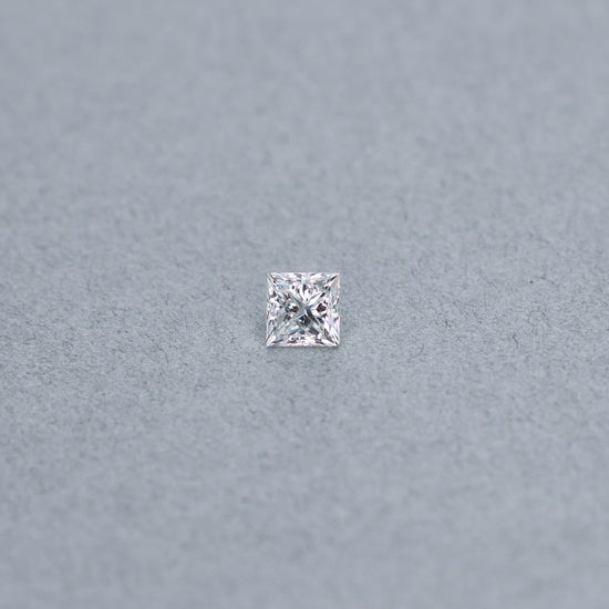 Princess cut 0.99 carat diamond graded GVS2 on a grey background
