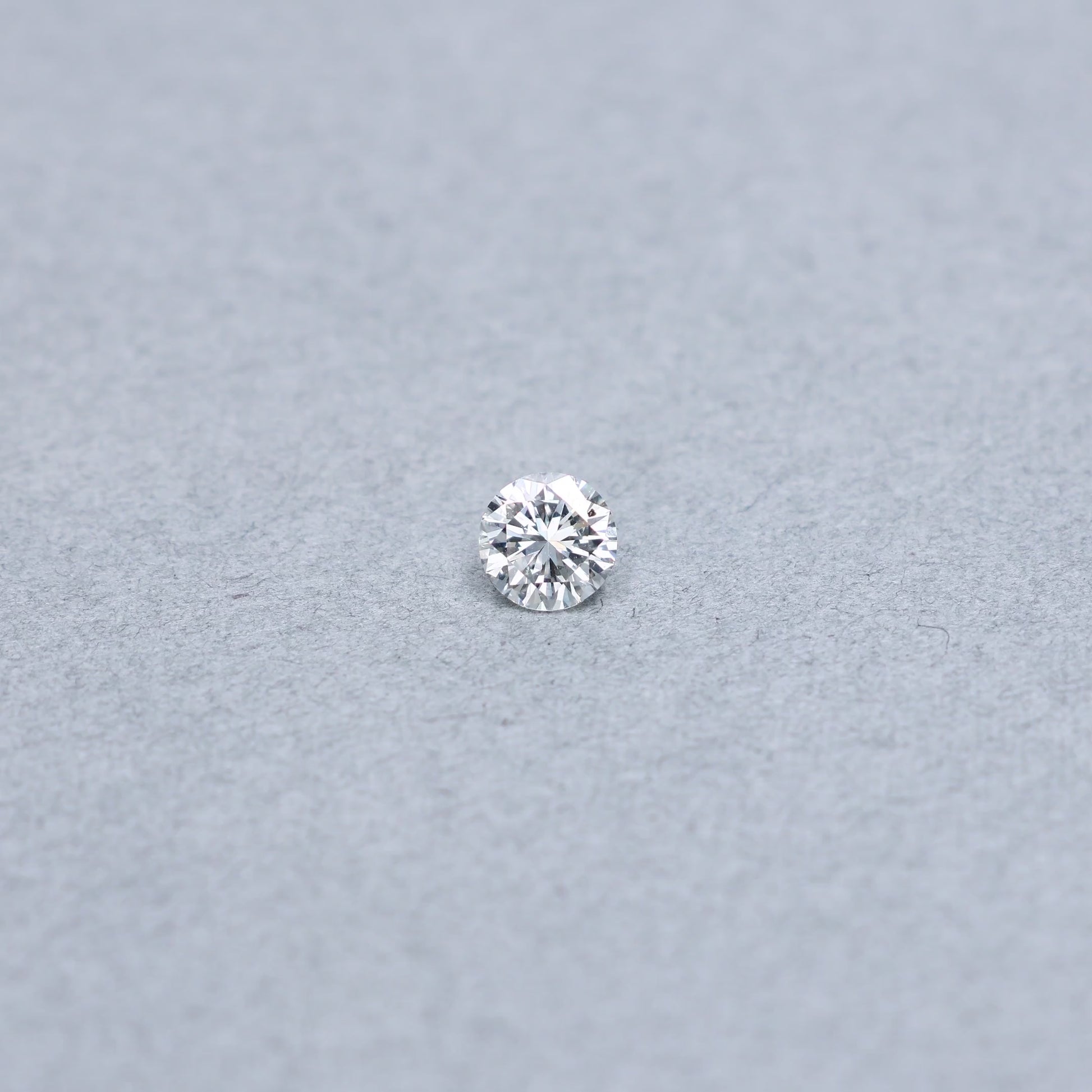 Round .70 carat GIA certified diamond graded DSI1 on a grey background