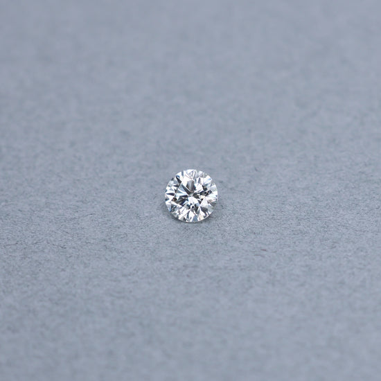 Round 0.90 carat GIA certified diamond graded JVS2 on a grey background