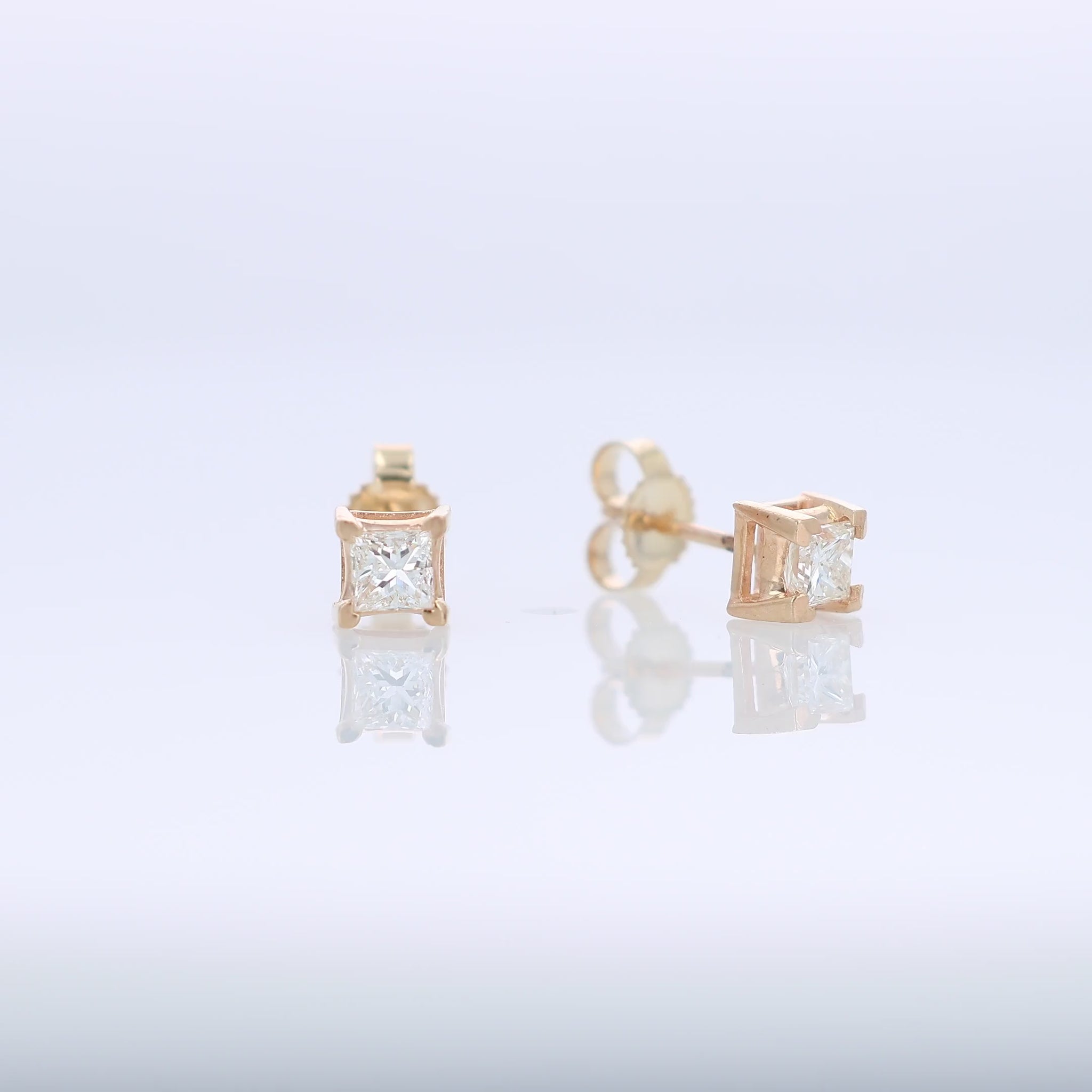 Yellow gold princess cut diamond stud earrings totaling 0.48 carats on a white background