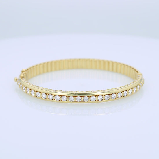Yellow gold bracelet with a diamond center row on a white background