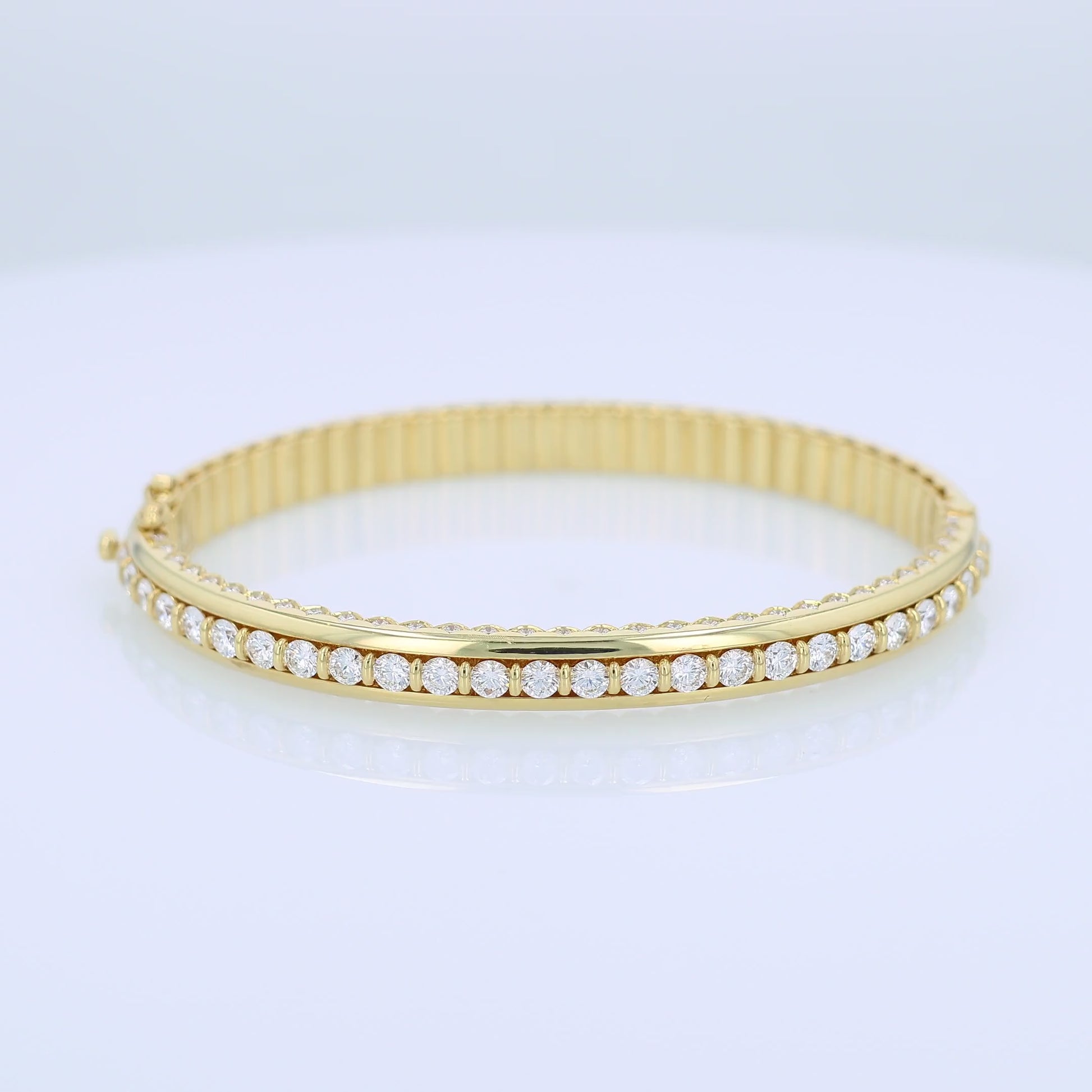Yellow gold bracelet with a diamond center row on a white background
