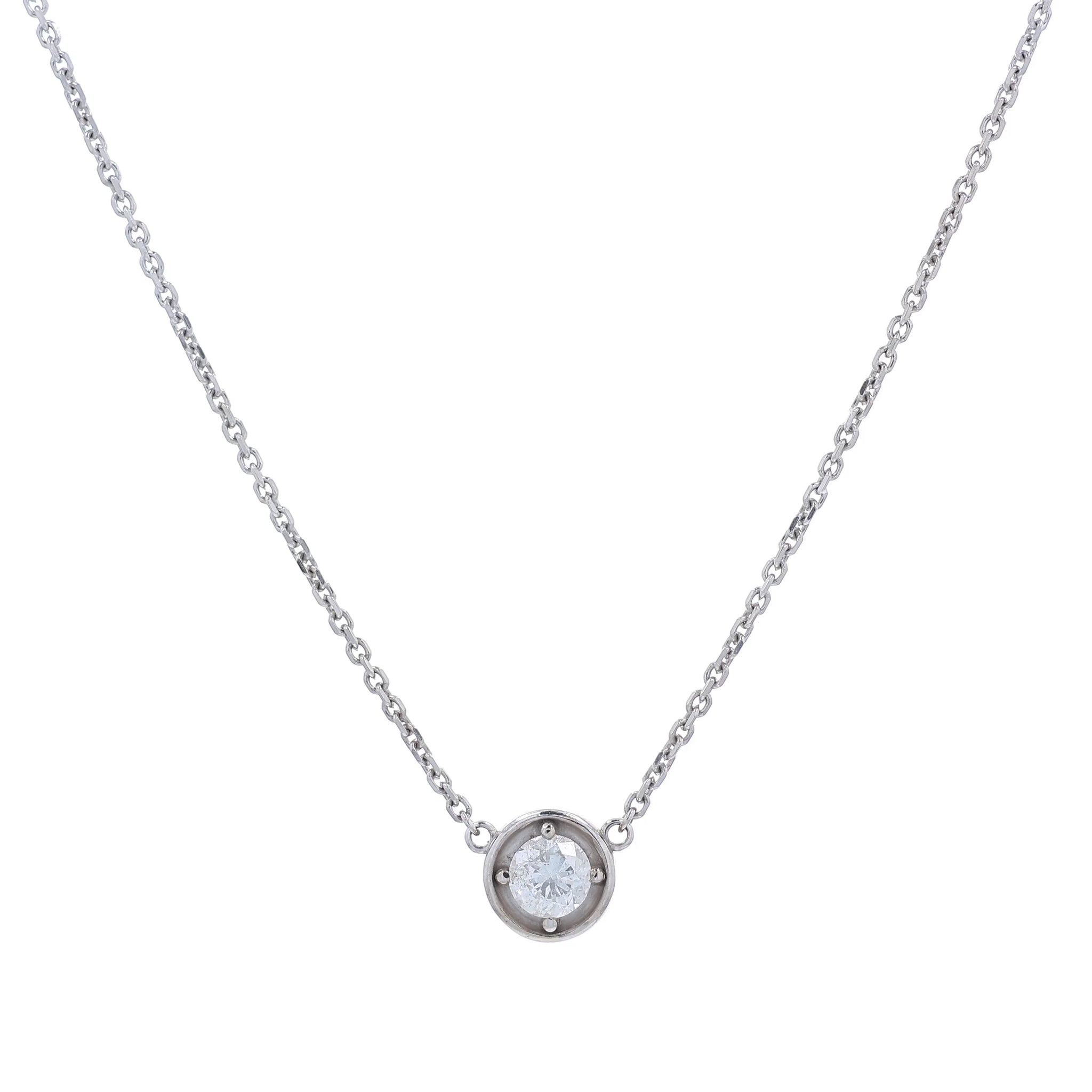 A delicate white gold chain necklace with a small round pendant holding a clear round-cut diamond, displayed against a solid white background.