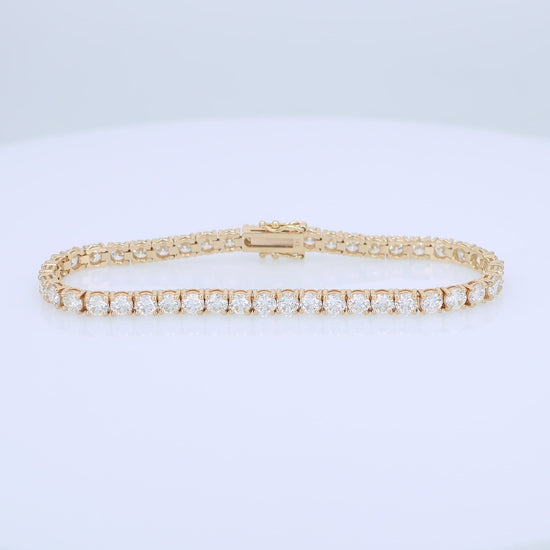 Yellow gold 9.00 carat diamond tennis bracelet on a white background