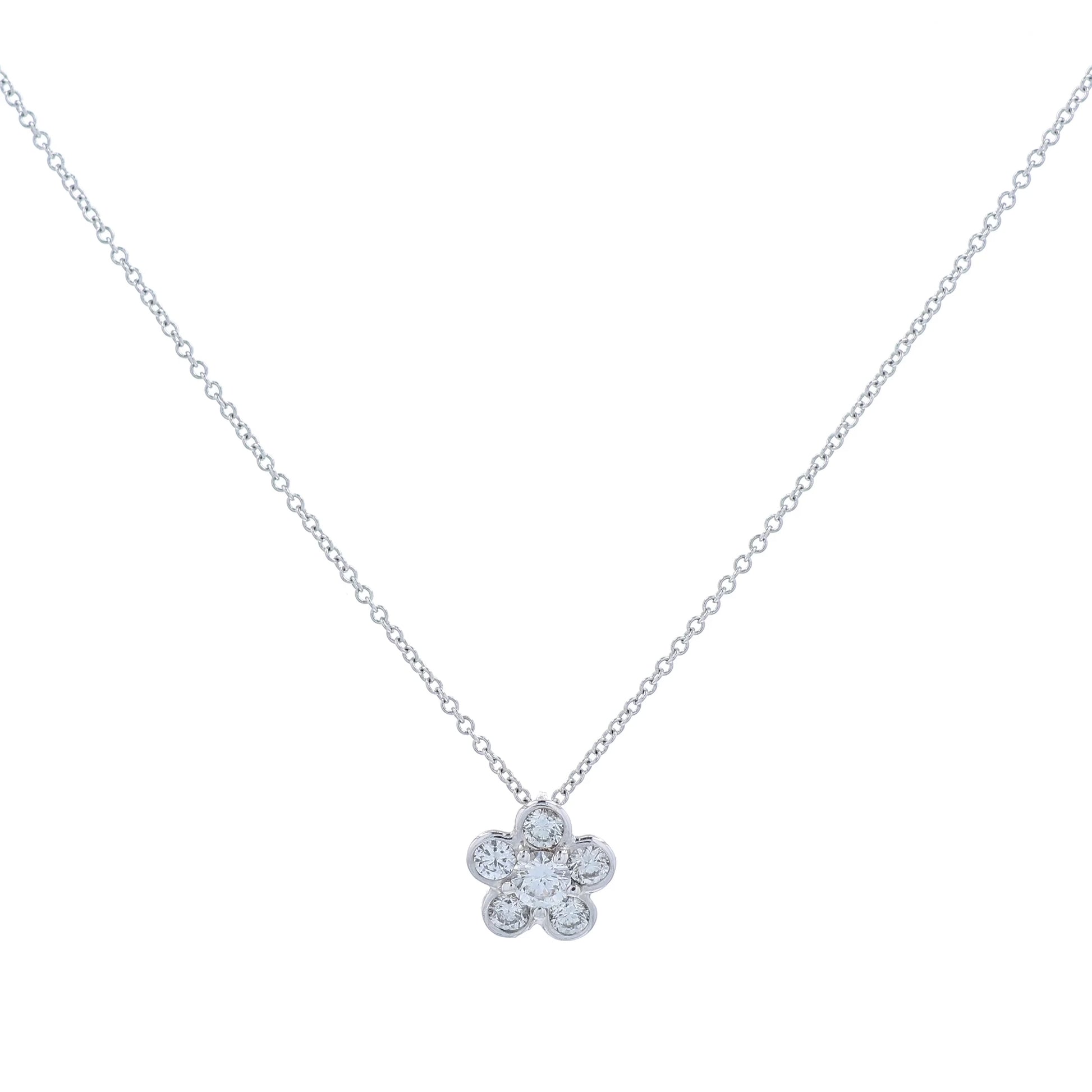 White gold flower shape diamond pendant necklace on a white background